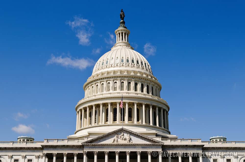 The white dome of the United States Capitol building against a clear blue sky.