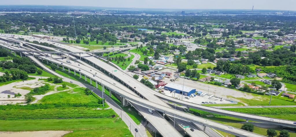 Aerial view of intersecting highways and buildings, surrounded by greenery—showcasing Leadership Louisiana's impact on urban development.
