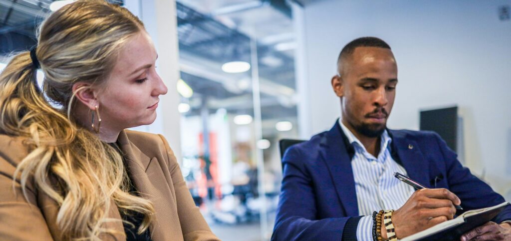 man in black suit jacket holding black smartphone